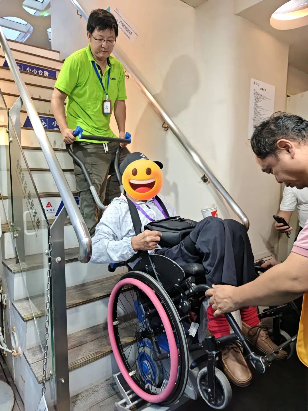 展大工作人员操作爬楼机协助残友登船